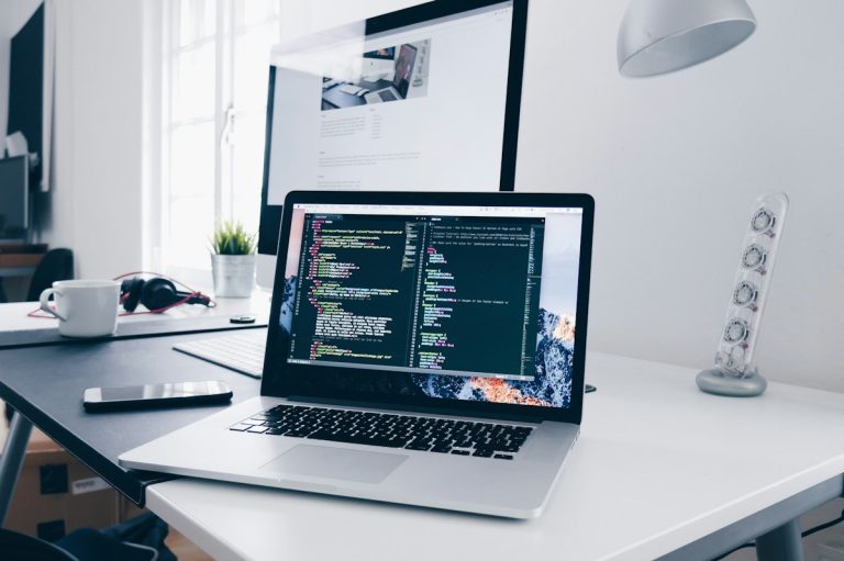 Remote developer coding on laptop with cloud architecture diagrams